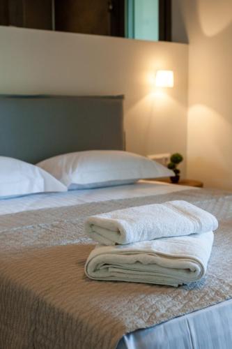 a bed with two towels sitting on top of it at Ktima Fabiatos in Skala Kefalonias