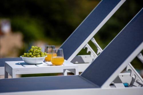 a table with two glasses of orange juice and a bowl of grapes at Ktima Fabiatos in Skala Kefalonias