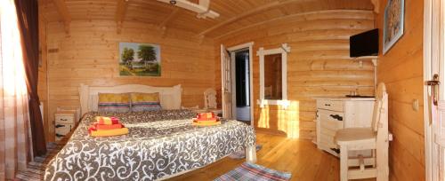 a bedroom with a bed in a log cabin at Dayarta in Skhidnitsa