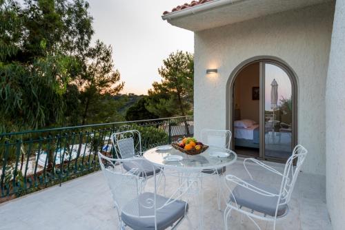 a patio with a table and chairs on a balcony at Ktima Fabiatos in Skala Kefalonias