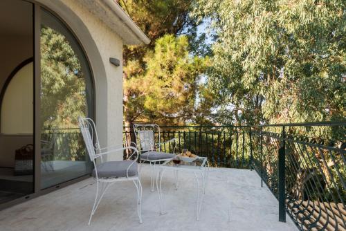 two chairs and a table on a balcony at Ktima Fabiatos in Skala Kefalonias