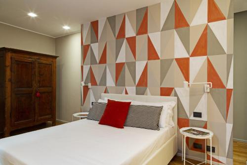 a bedroom with a white bed and a geometric wall at Design in Genoa City Center by Wonderful Italy in Genova