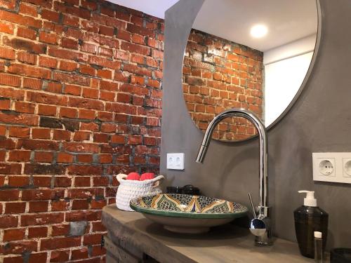 a bathroom with a sink and a brick wall at Ferienhaus Paradiso in Kirchheim unter Teck
