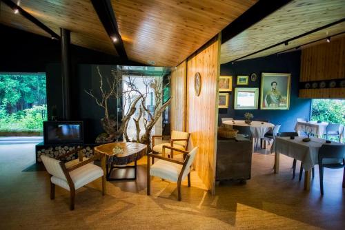 sala de estar con mesa, sillas y TV en Furnas Lake Forest Living en Furnas