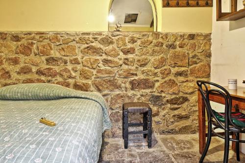 1 dormitorio con pared de piedra, cama y mesa en KulturBerlin, en Sucre