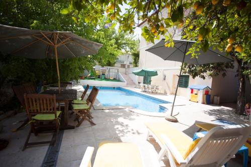 a pool with chairs and tables and an umbrella at Casa dos Limoeiros in Évora