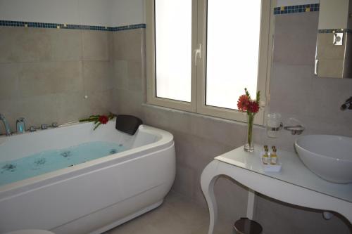 a white bathroom with a tub and a sink at Residenza Wagner in Palermo