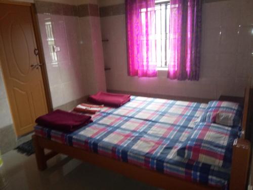 a bed in a room with pink windows and pink curtains at Gokarna RSN STAY in Top Floor for the Young & Energetic people of the Universe in Gokarna