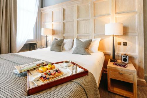 a hotel room with a tray of food on a bed at The Scotsman Hotel in Edinburgh