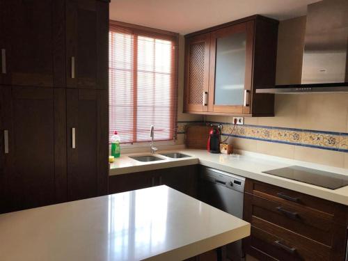 a kitchen with wooden cabinets and a white counter top at Casa perla de Andalucía en costa de Granada in Calahonda