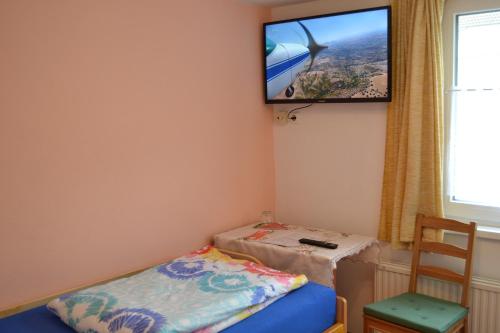 a room with a bed and a tv on the wall at Pension Haus Rohrmoser in Annaberg im Lammertal
