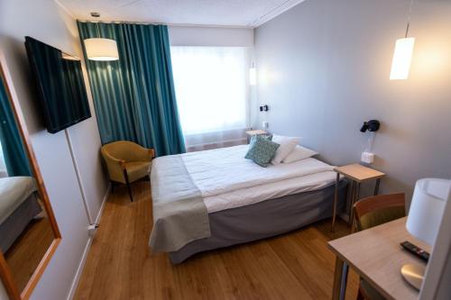a small room with a bed and a window at Hotel Hirvi in Äänekoski