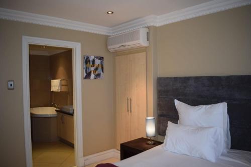 a hotel room with a bed and a bathroom at Two bedroom apartment at the Sails in Durban