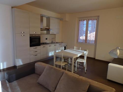 sala de estar con sofá, mesa y cocina en Casa Costa Outlet 5, en Serravalle Scrivia