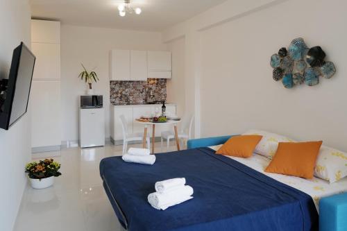 un soggiorno con letto blu e una cucina di La Casa Di Dodo a Taormina