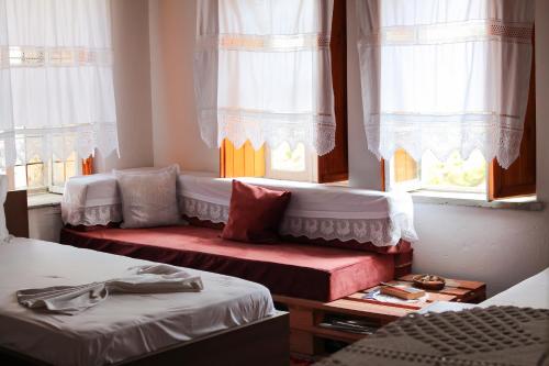 a room with two beds and two windows at Lori's traditional house in Gjirokastër