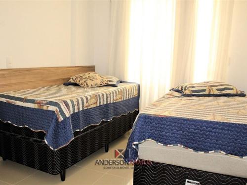 2 Betten nebeneinander in einem Zimmer in der Unterkunft 1007 Residencial Fontini Apto 302 - Praia de Bombas in Bombinhas