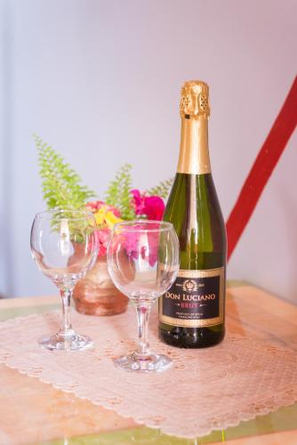a bottle of champagne and two wine glasses on a table at Calabash Apartment-Hotel in Kotu