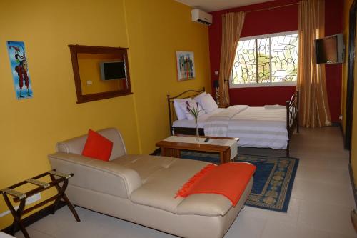 a living room with two beds and a couch at Calabash Apartment-Hotel in Kotu