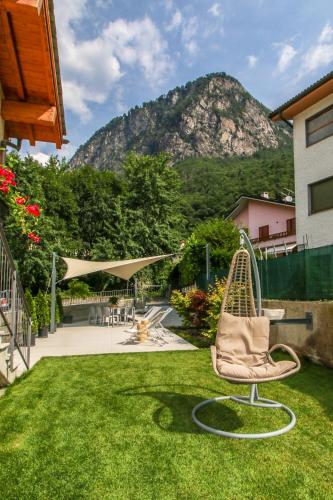 a chair in a yard with a mountain in the background at Sofi apartment in Chiavenna