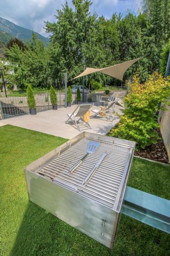 a bed sitting on the grass in a yard at Sofi apartment in Chiavenna