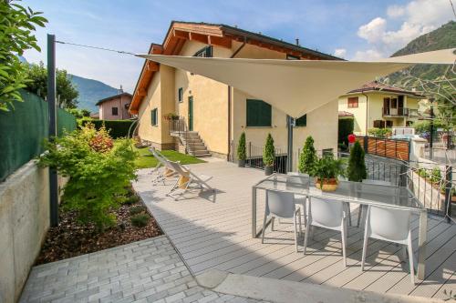 a patio with a table with chairs and an umbrella at Sofi apartment in Chiavenna