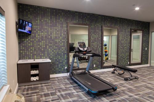 a room with a gym with a treadmill and a mirror at La Quinta by Wyndham Houston East at Normandy in Houston