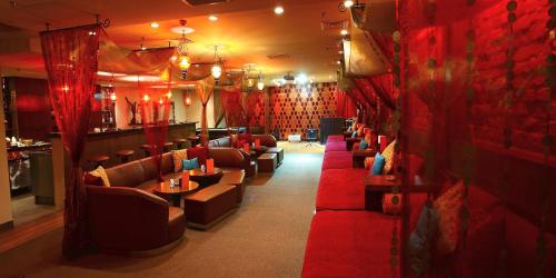 a bar with red curtains and couches in a room at Radisson Blu Dhaka Water Garden in Dhaka