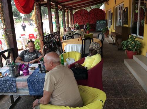a group of people sitting at a table in a restaurant at Calabash Apartment-Hotel in Kotu