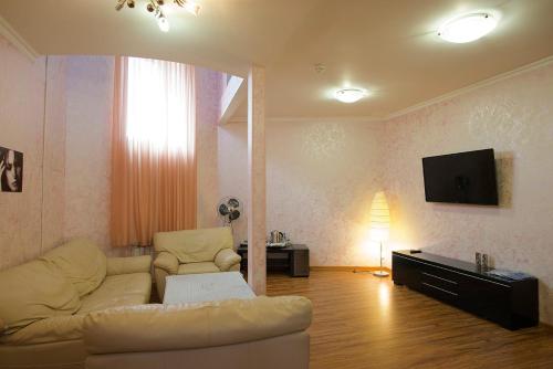 a living room with a couch and a tv at Edem Hotel in Zelenograd