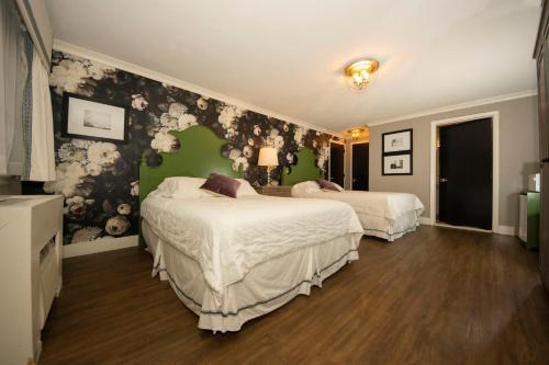 a bedroom with two beds and a green wall at Simmons Motel and Suites in Hershey