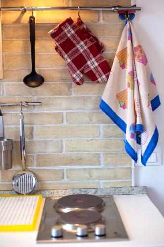 a kitchen with a stove and towels on a wall at Locazioni Turistiche By Max in Montegrotto Terme