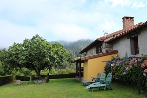 una casa con dos sillas azules en un patio en La Quintana Sinariega, en Sinariega