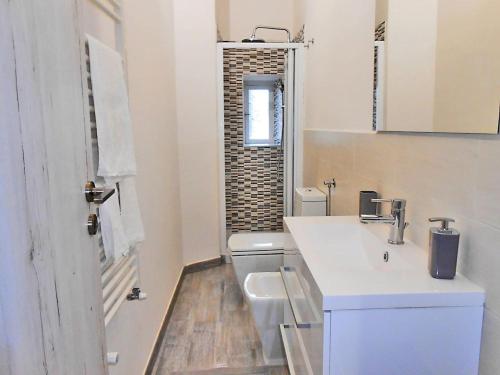 a white bathroom with a sink and a toilet at Vista su Lerici in Lerici