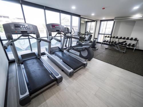 a gym with treadmills and ellipticals in a building at Tassana Place in Chon Buri