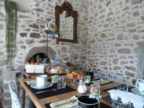 - une table avec de la nourriture dans une pièce avec un mur en pierre dans l'établissement Les chambres du Couraud, à Saint-Aubin-des-Ormeaux