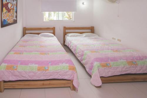 2 nebeneinander sitzende Betten in einem Schlafzimmer in der Unterkunft Cabaña Coveñitas 2 in Coveñas