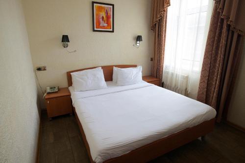 Un pat sau paturi într-o cameră la Edem Hotel