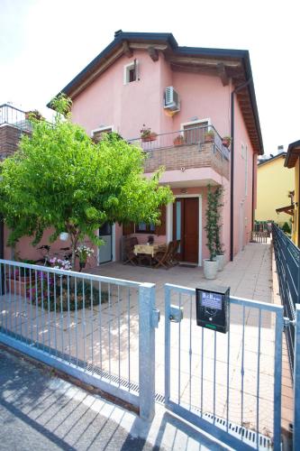a pink house with a fence in front of it at Locazioni Turistiche By Max in Montegrotto Terme