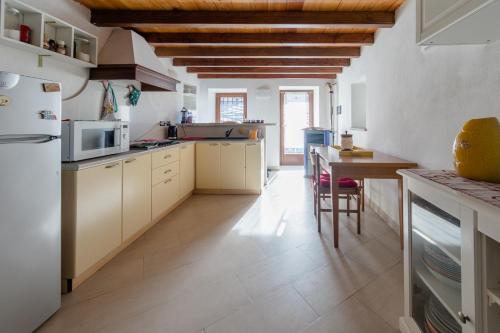eine Küche mit weißen Geräten und einer Holzdecke in der Unterkunft Maison Bellevue - locazione turistica breve in Aosta