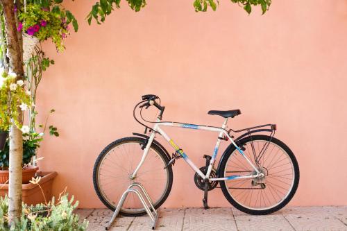 una bicicleta estacionada junto a una pared rosa en Locazioni Turistiche By Max en Montegrotto Terme