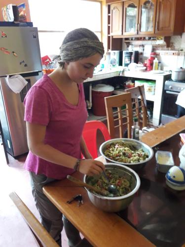 a woman preparing a bowl of food on a table at Shoffi's House Backpackers in Tarapoto