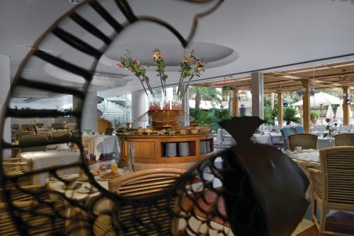 a dining room with a table and chairs and flowers at Royal Beach Eilat by Isrotel Exclusive in Eilat