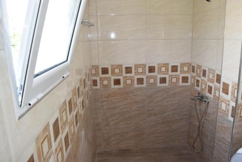 a bathroom with a shower with a glass door at Velco BB Himara in Himare