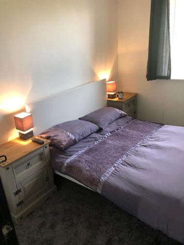 a bed in a bedroom with two lamps on a table at Just by the Gormly MenAnother Place Near Liverpool 13 Abbortford Road Crosby Liverpool L23 6ux in Crosby