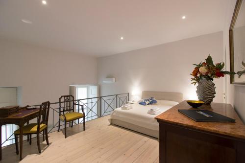 ナポリにあるPalazzo d'Auria ApartHotelのベッド、デスク、デスクが備わるホテルルームです。