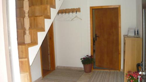a hallway with a staircase and a door with a potted plant at Apartments Đurđić in Žabljak