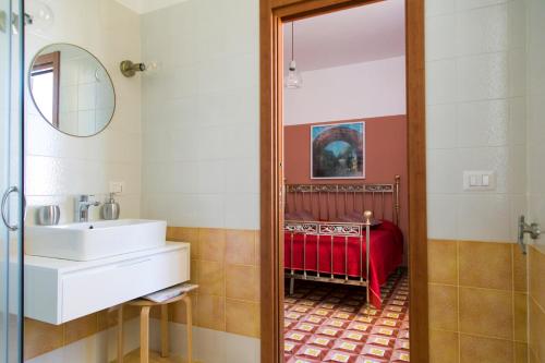 La salle de bains est pourvue d'un lavabo et d'un miroir. dans l'établissement A Casa di Nina Guest House, à Naples