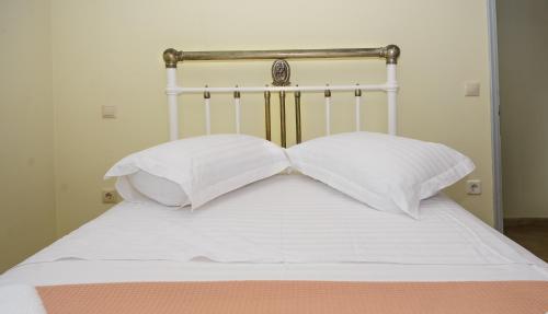a bed with white sheets and two pillows at Kokonis House in Ayia Evfimia
