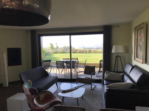 Il comprend un salon avec un canapé et des chaises. dans l'établissement Coolcottage des 2 Caps, à Leulinghen-Bernes